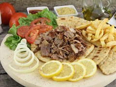 small-Plate of traditional Greek gyros with meat, fried potatoes, tomato and onion _75689422