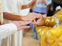 small-Bride and groom hands with ring during orthodox church wedding ceremony