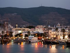 Обычные деревянные лодки в порту города Кос, Бар-стрит за лодками, центр ночной жизни туристического города на острове Кос Греция